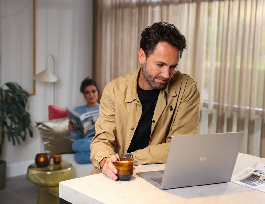 Man bij laptop in gezellige setting